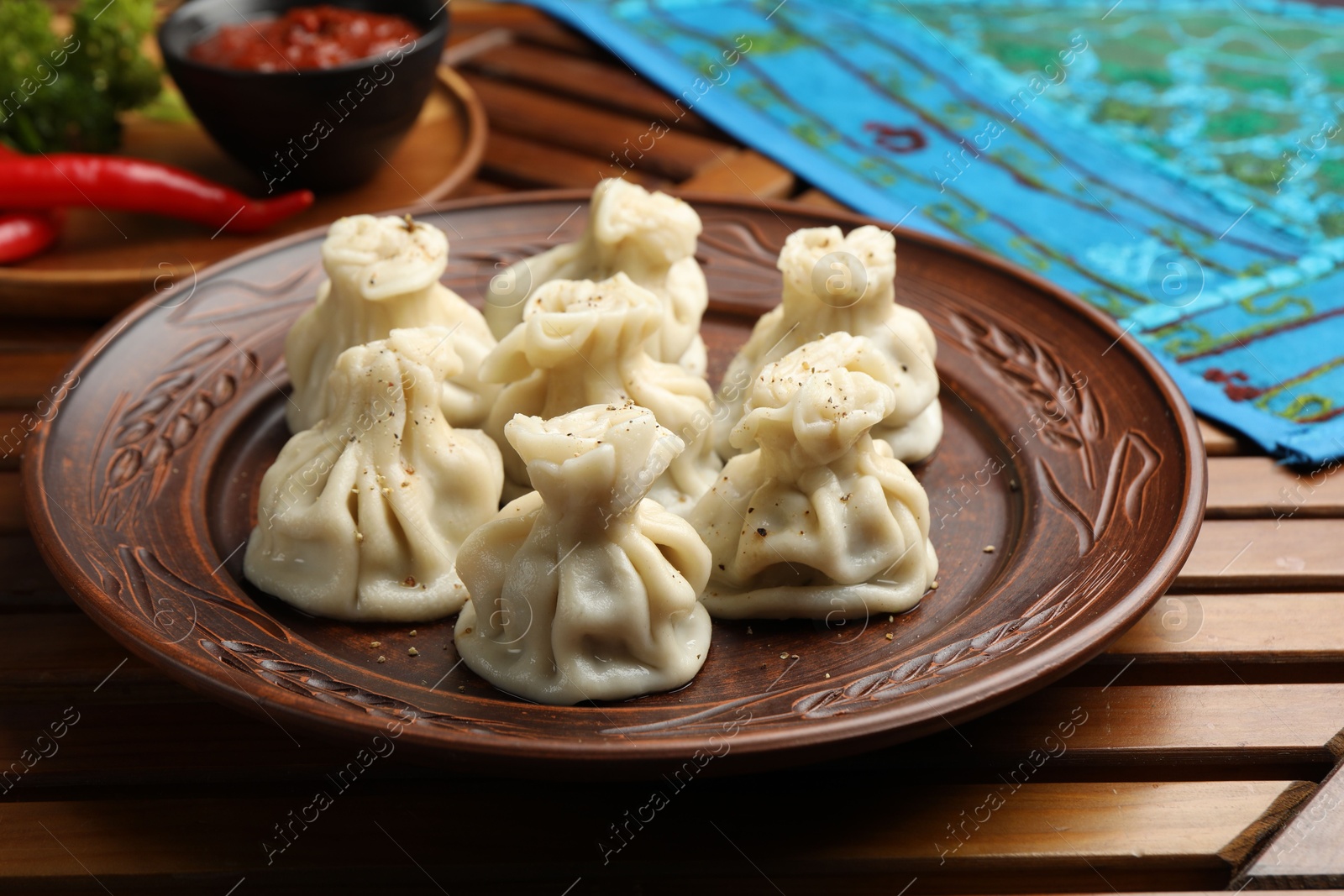 Delicious khinkali served on wooden table, closeup Photo of Delicious khinkali served on wooden table, closeup