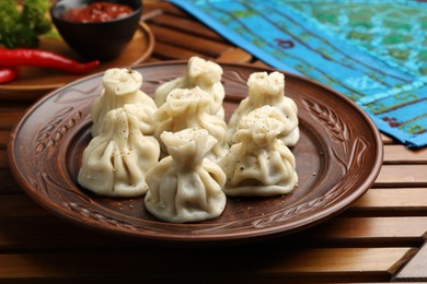Photo of Delicious khinkali served on wooden table, closeup