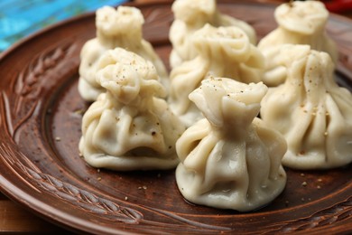 Photo of Many delicious khinkali on plate, closeup view