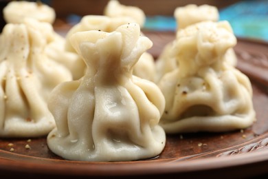 Photo of Many delicious khinkali on plate, closeup view