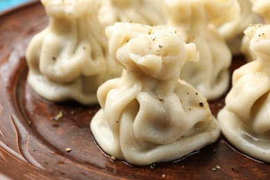 Photo of Many delicious khinkali on plate, closeup view