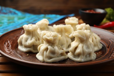 Photo of Delicious khinkali served on wooden table, closeup