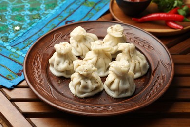 Photo of Delicious khinkali served on wooden table, closeup