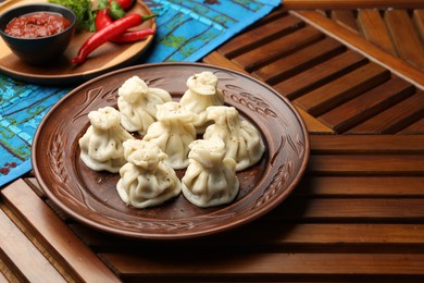 Photo of Delicious khinkali served on wooden table, space for text