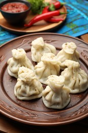 Photo of Delicious khinkali served with spices on table, closeup