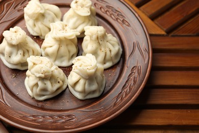 Photo of Delicious khinkali with spices on wooden table, above view