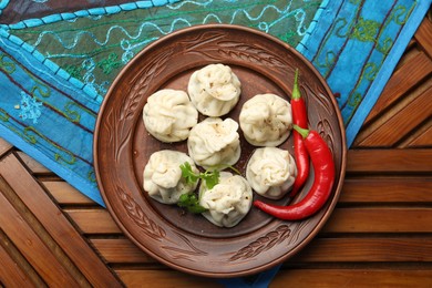 Photo of Delicious khinkali with spices on wooden table, top view