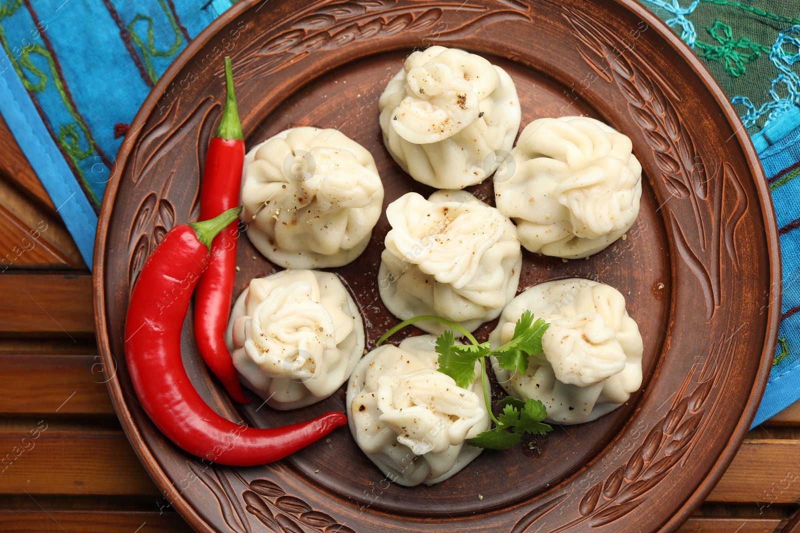 Delicious khinkali with spices on wooden table, top view Photo of Delicious khinkali with spices on wooden table, top view