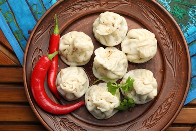 Photo of Delicious khinkali with spices on wooden table, top view