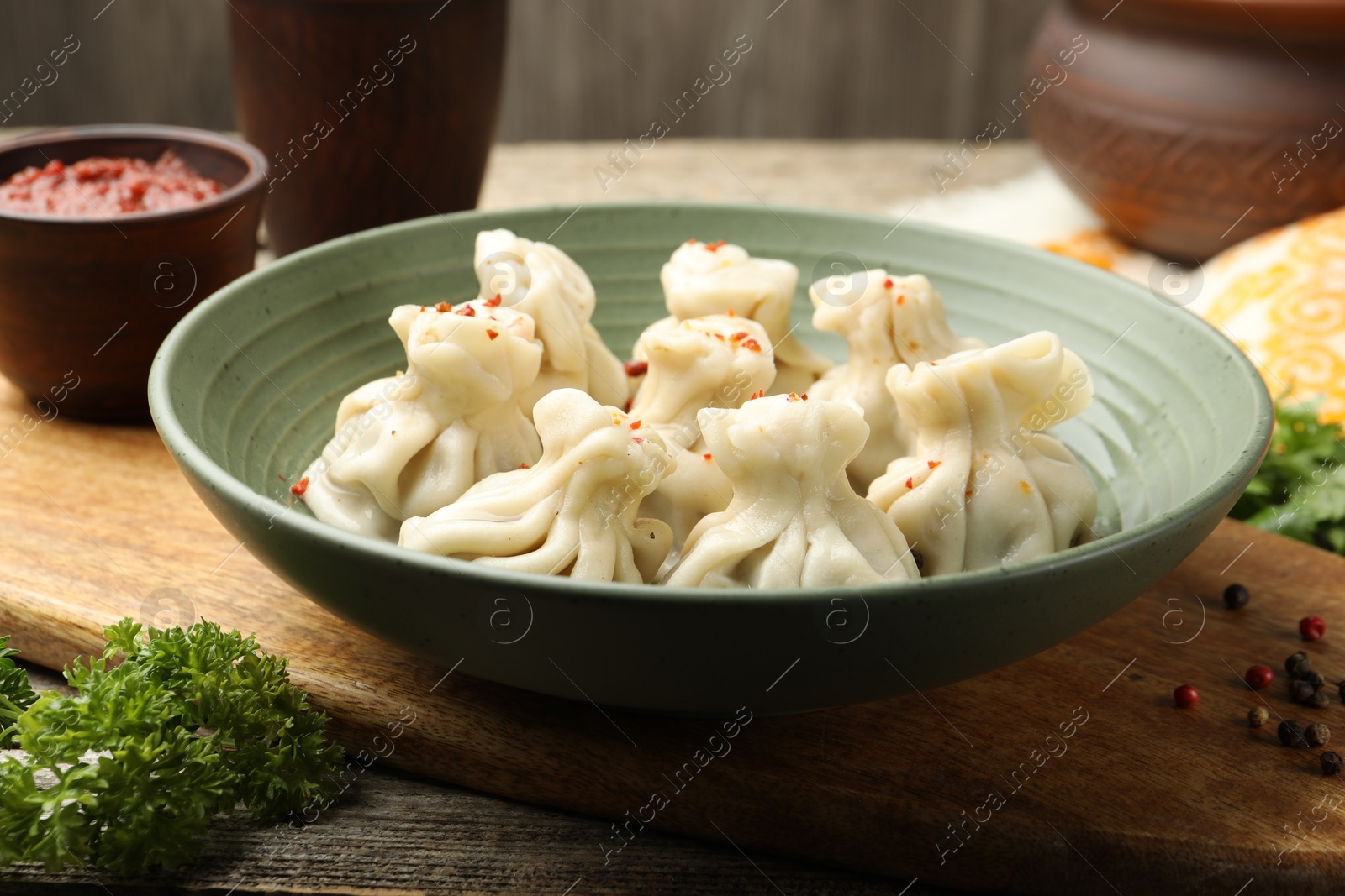 Delicious khinkali served on wooden table, closeup Photo of Delicious khinkali served on wooden table, closeup