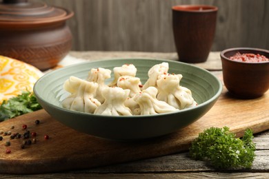 Photo of Delicious khinkali served on wooden table, closeup