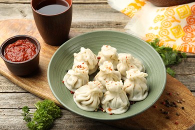 Photo of Delicious khinkali served on wooden table, above view