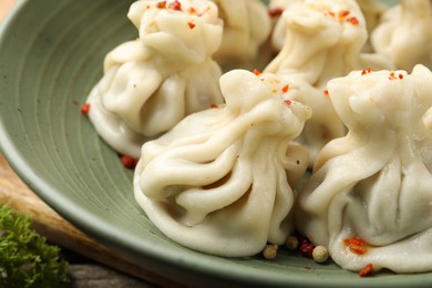 Photo of Delicious khinkali with spices in bowl on table, closeup