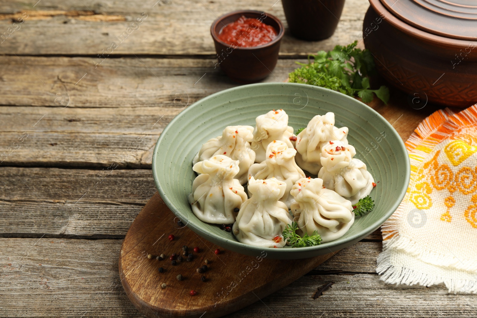 Photo of Delicious khinkali served on wooden table, space for text