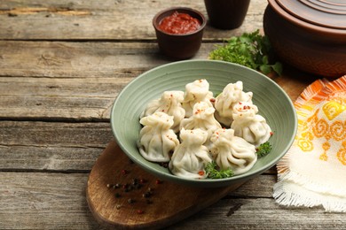 Photo of Delicious khinkali served on wooden table, space for text