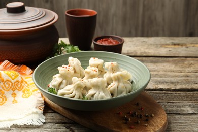 Photo of Delicious khinkali served on wooden table, closeup