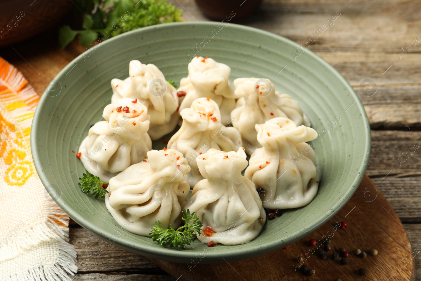 Delicious khinkali with spices on wooden table, closeup Photo of Delicious khinkali with spices on wooden table, closeup