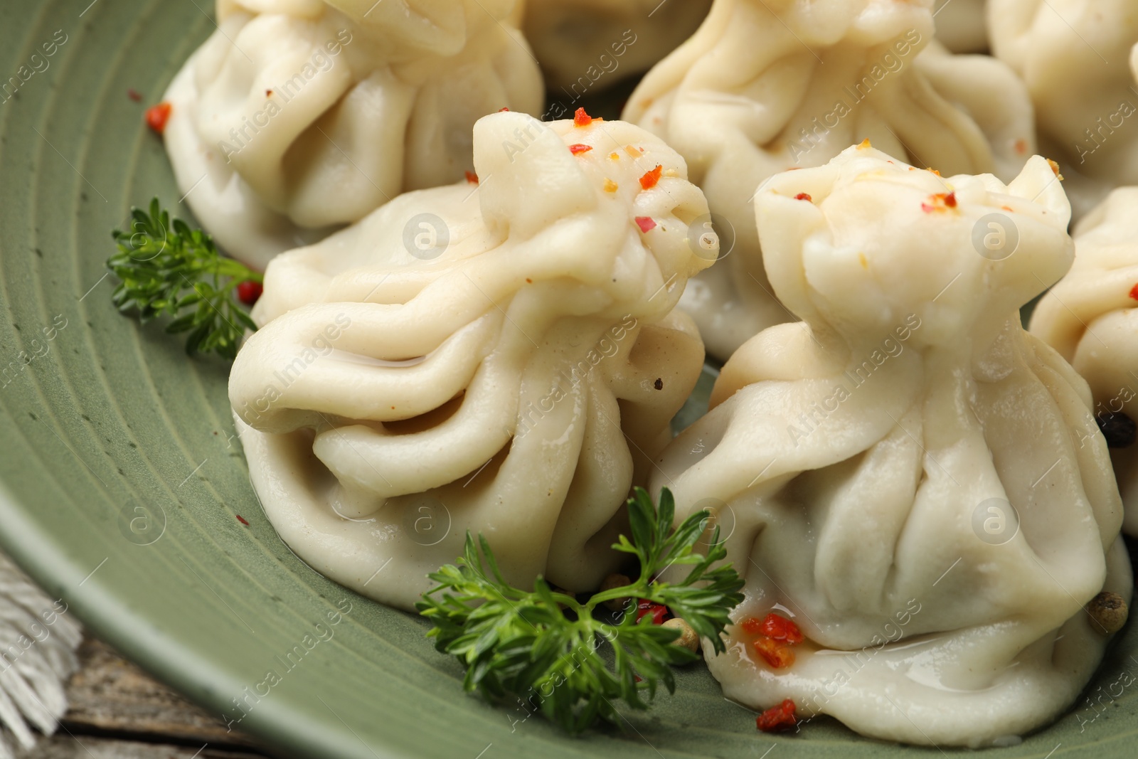 Delicious khinkali with spices in bowl on table, closeup Photo of Delicious khinkali with spices in bowl on table, closeup