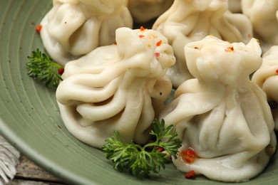 Photo of Delicious khinkali with spices in bowl on table, closeup
