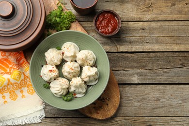 Photo of Delicious khinkali served on wooden table, flat lay