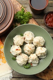 Photo of Delicious khinkali served on wooden table, flat lay