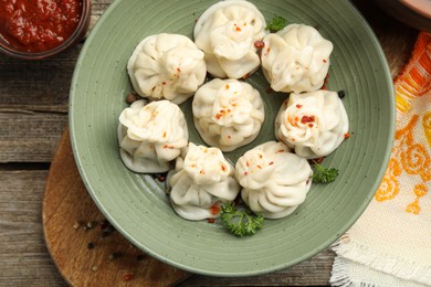 Photo of Delicious khinkali served on wooden table, flat lay