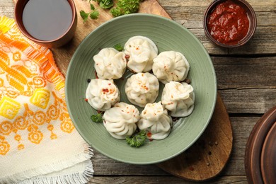 Photo of Delicious khinkali served on wooden table, flat lay