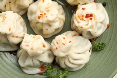 Photo of Delicious khinkali with spices in bowl, top view