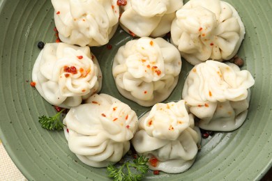Photo of Delicious khinkali with spices in bowl, top view