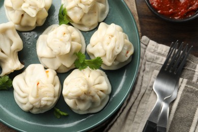 Photo of Delicious khinkali served with cilantro on table, flat lay