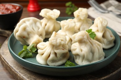 Photo of Delicious khinkali served with cilantro on table, closeup