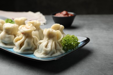 Photo of Delicious khinkali served on grey table, closeup