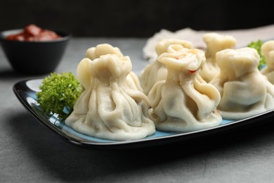 Photo of Delicious khinkali served on grey table, closeup
