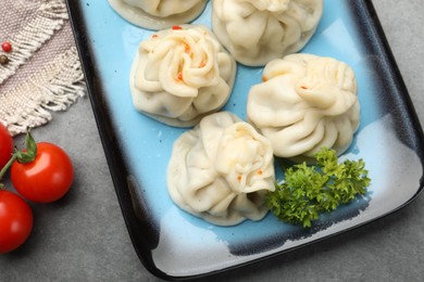 Photo of Delicious khinkali served on grey table, flat lay