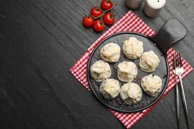 Photo of Delicious khinkali served on black table, flat lay. Space for text