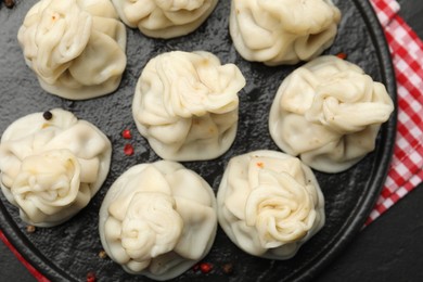 Photo of Delicious khinkali served on black table, top view