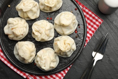 Photo of Delicious khinkali served on black table, flat lay