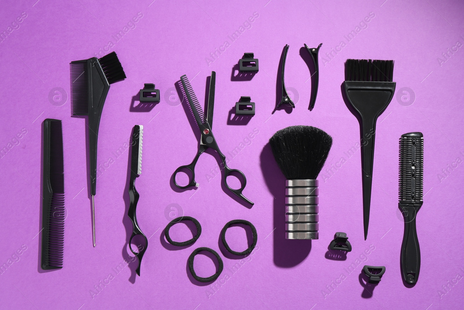 Different hairdresser's tools on violet background, flat lay Photo of Different hairdresser's tools on violet background, flat lay