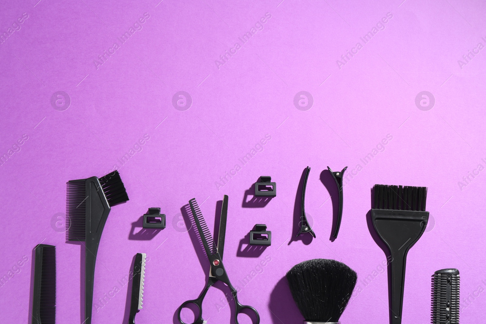 Different hairdresser's tools on violet background, flat lay. Space for text Photo of Different hairdresser's tools on violet background, flat lay. Space for text