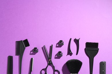Photo of Different hairdresser's tools on violet background, flat lay. Space for text