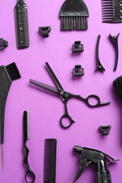 Photo of Different hairdresser's tools on violet background, flat lay