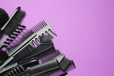 Photo of Different hairdresser's tools on violet background, flat lay. Space for text