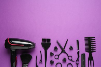 Photo of Different hairdresser's tools on violet background, flat lay. Space for text