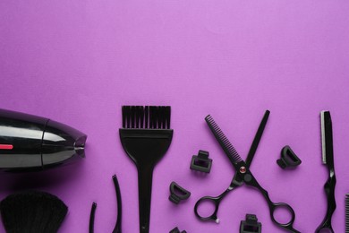 Photo of Different hairdresser's tools on violet background, flat lay. Space for text