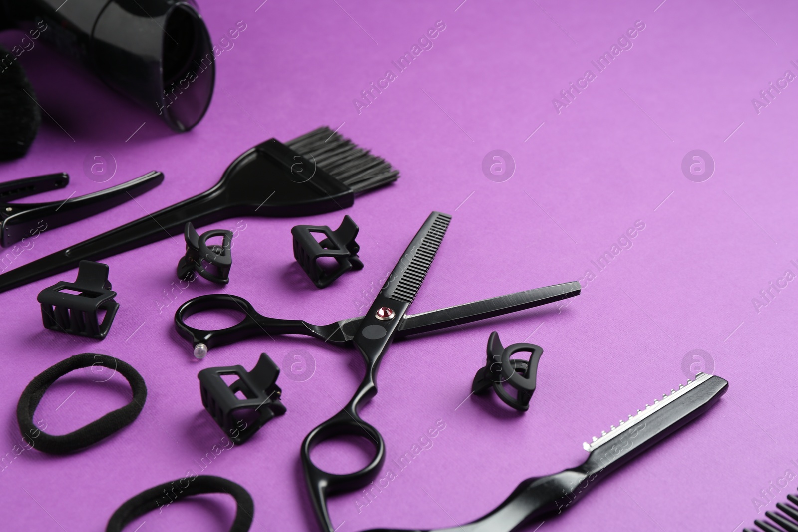 Different hairdresser's tools on violet background, closeup. Space for text Photo of Different hairdresser's tools on violet background, closeup. Space for text