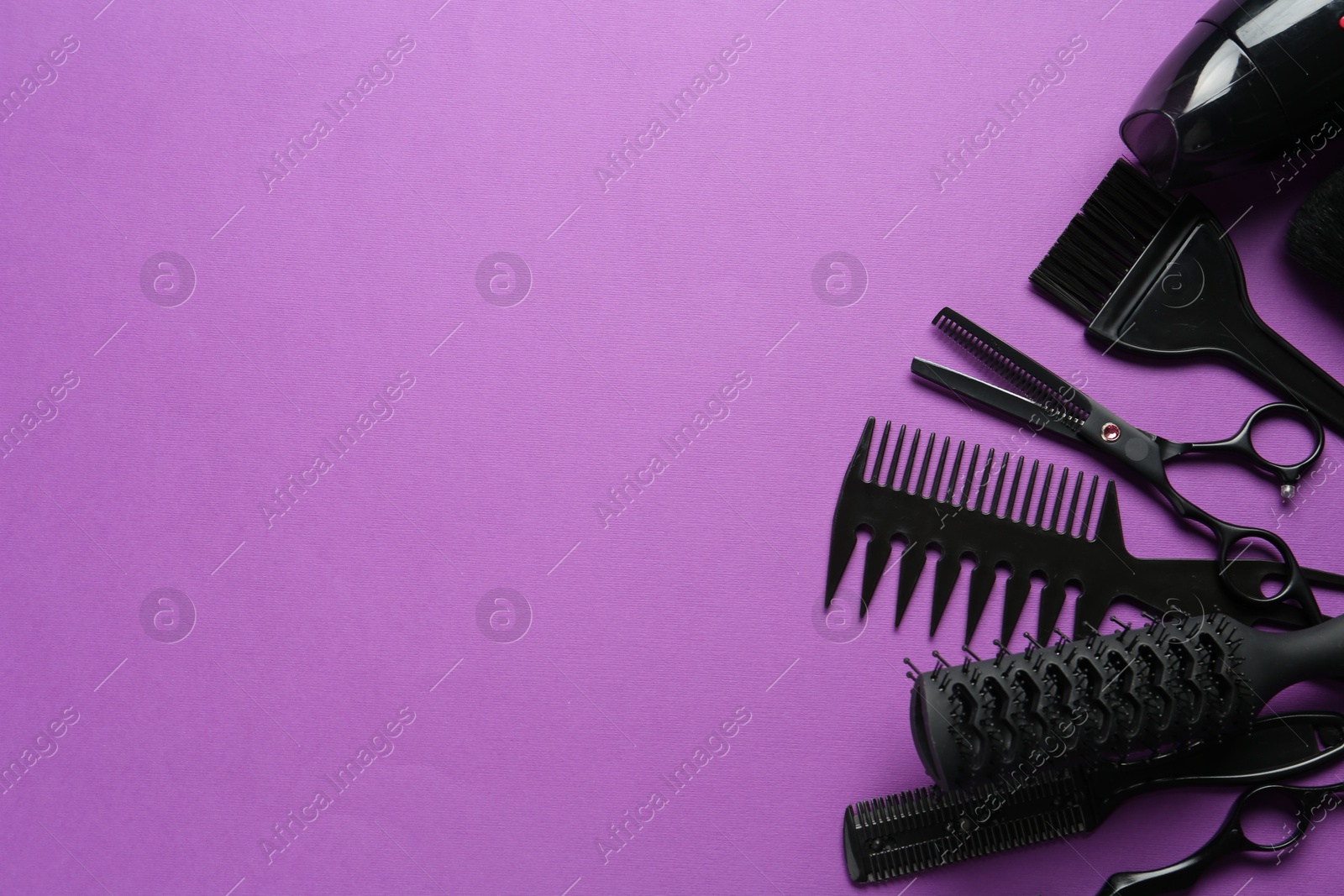 Different hairdresser's tools on violet background, flat lay. Space for text Photo of Different hairdresser's tools on violet background, flat lay. Space for text