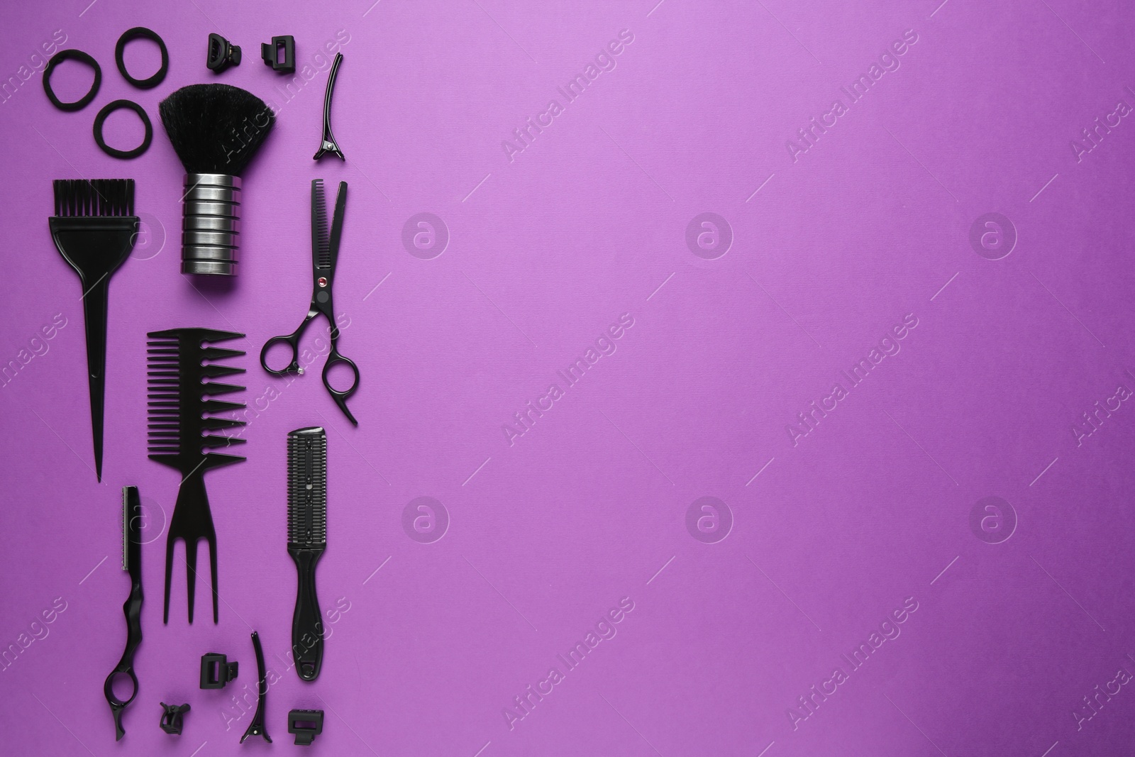Photo of Different hairdresser's tools on violet background, flat lay. Space for text