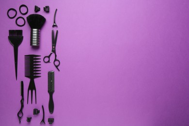 Photo of Different hairdresser's tools on violet background, flat lay. Space for text