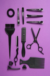 Photo of Different hairdresser's tools on violet background, flat lay
