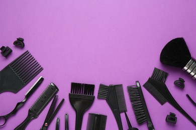Photo of Different hairdresser's tools on violet background, flat lay. Space for text